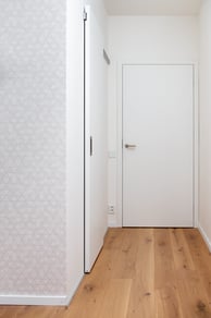 Moderní interiér s bílými dveřmi a dřevěnou podlahou